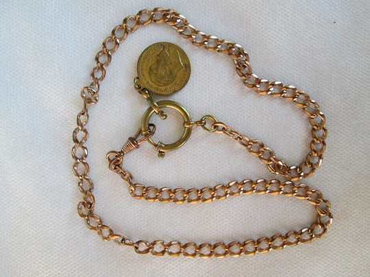 Pocket watch chain. Open braided links. Gold plated. Coin pendant. 1911