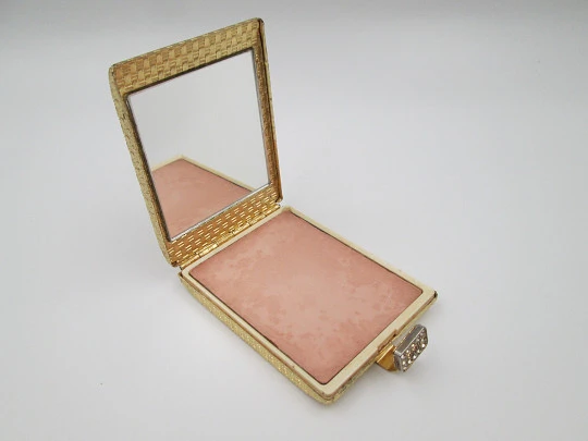 Polvera para mujer. Metal dorado con trama decorativa. Cierre gemas blancas. 1950