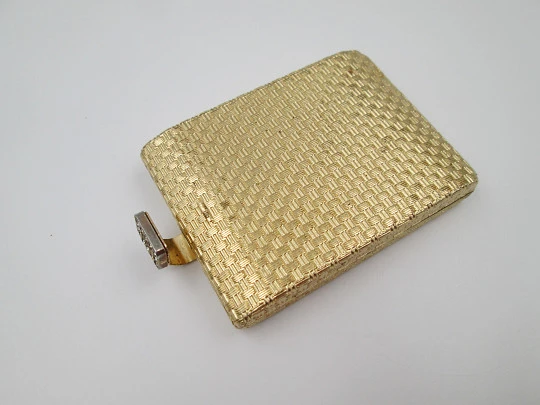 Polvera para mujer. Metal dorado con trama decorativa. Cierre gemas blancas. 1950