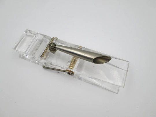 Portaplumas de escritorio. Plástico transparente y metal. Pinza sujetapapeles
