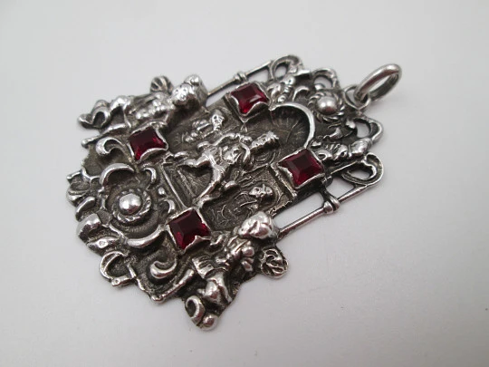 Portico pendant medal. Sterling silver and garnets. King with cherubs relief scene