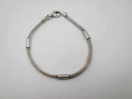 Pulsera unisex de cordón en plata de ley. Adornos tubulares. Cierre mosquetón. Italia