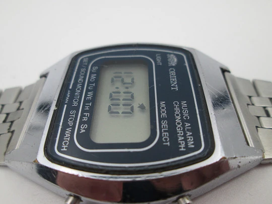 Raro cronógrafo digital Orient. Metal cromado y acero inoxidable. Brazalete. 1970. Japón