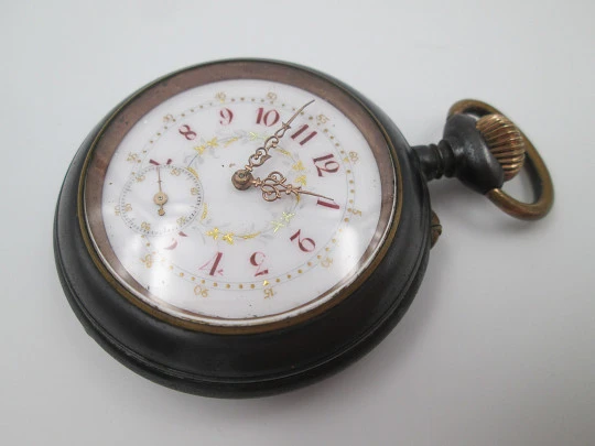 Reloj bolsillo hierro pavonado y metal dorado. Dial decorado. Remontoir. 1900