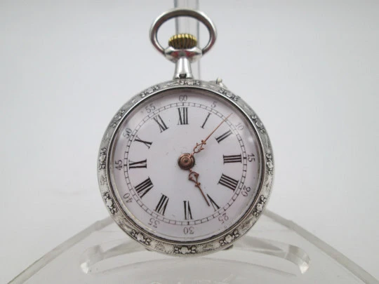 Reloj bolsillo plata ley. Esfera porcelana. Remontoir con pulsador. Motivos florales. 1890