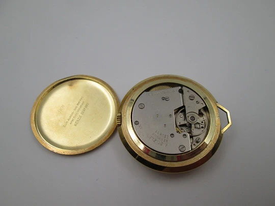 Reloj colgante Kienzle Markant. Metal chapado oro. Cuerda manual. Alemania. 1960
