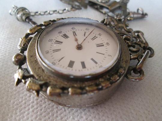 Reloj de bolsillo con chatelaine. Metal plateado. Cuerda a llaves. Siglo XIX