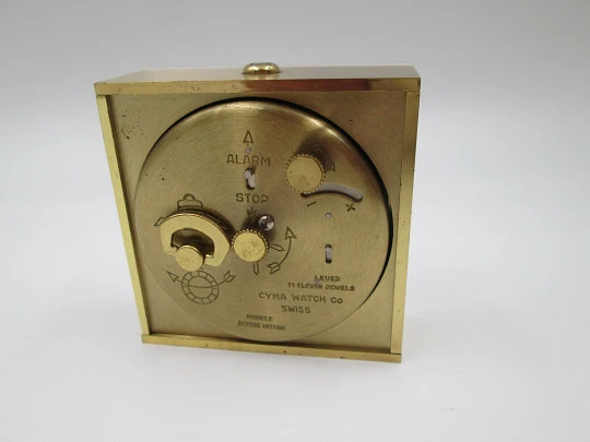 Reloj despertador de sobremesa Cyma. Cuerda manual. Bronce y metacrilato. Suiza. 1960