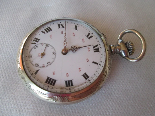 Reloj francés de alpaca. Remontoir con pulsador. 1910. Fondo decorado