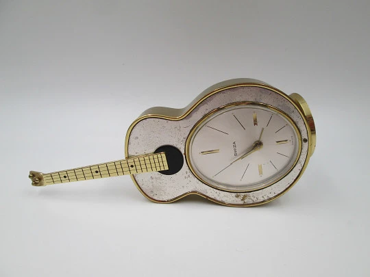 Reloj musical de sobremesa Swiza. Cuerda manual. Bronce. Forma de guitarra. 1970 Reloj musical de sobremesa Swiza. Cuerda manual. Bronce. Forma de guitarra. 1970