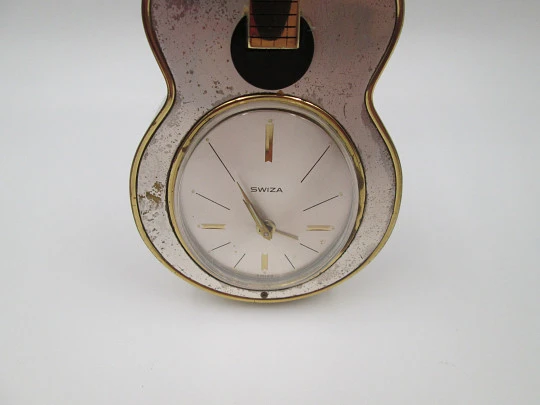 Reloj musical de sobremesa Swiza. Cuerda manual. Bronce. Forma de guitarra. 1970 Reloj musical de sobremesa Swiza. Cuerda manual. Bronce. Forma de guitarra. 1970