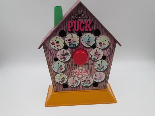 Reloj musical Puck con hucha. Hojalata litografiada y plástico. Juguetes Rico. 1970