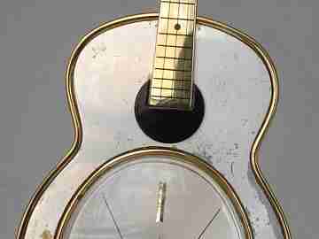 Reloj musical Swiza. Cuerda manual. Bronce. Forma guitarra. 1970