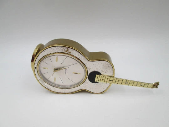 Reloj musical Swiza. Cuerda manual. Bronce. Forma guitarra. 1970 Reloj musical Swiza. Cuerda manual. Bronce. Forma guitarra. 1970