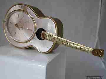 Reloj musical Swiza. Cuerda manual. Bronce. Forma guitarra. 1970