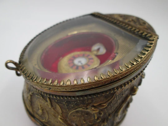 Relojera sobremesa decorada. Metal dorado y cristal biselado. 1900. Relieve