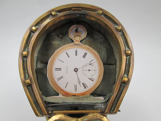 Relojera sobremesa. Bronce, peltre y cristal. 1900. Casco con herradura