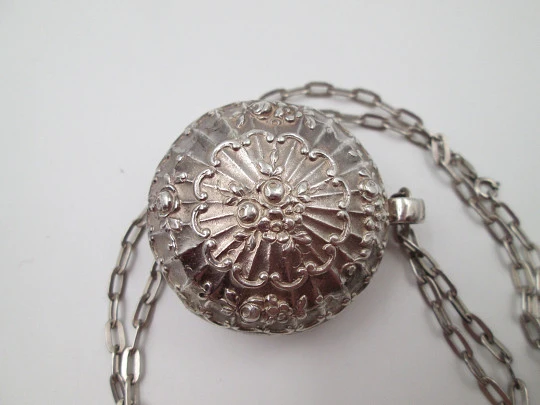 Round baby rattle with links chain. Sterling silver. Scrolls and floral motifs. Spain. 1960's