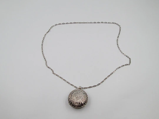 Round baby rattle with links chain. Sterling silver. Scrolls and floral motifs. Spain. 1960's