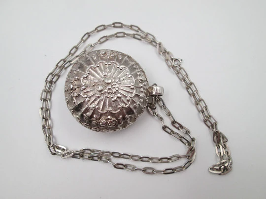 Round baby rattle with links chain. Sterling silver. Scrolls and floral motifs. Spain. 1960's