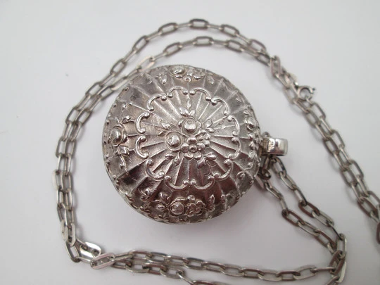 Round baby rattle with links chain. Sterling silver. Scrolls and floral motifs. Spain. 1960's