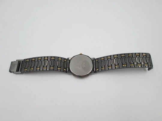 Seiko. Black and gold metal. Steel back. Quartz. Round case. Bracelet. 1980's. Japan