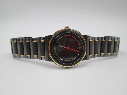 Seiko. Black and gold metal. Steel back. Quartz. Round case. Bracelet. 1980's. Japan