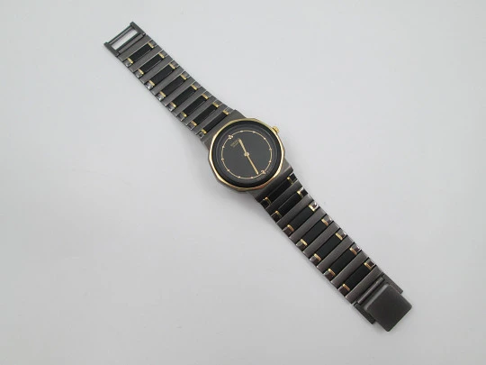 Seiko. Black and gold metal. Steel back. Quartz. Round case. Bracelet. 1980's. Japan