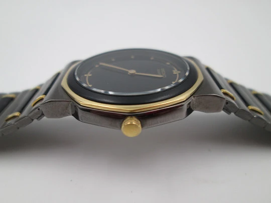 Seiko. Black and gold metal. Steel back. Quartz. Round case. Bracelet. 1980's. Japan