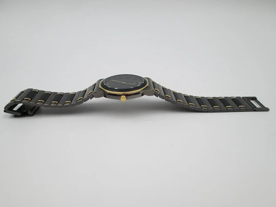 Seiko. Black and gold metal. Steel back. Quartz. Round case. Bracelet. 1980's. Japan