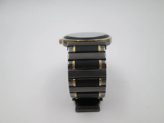 Seiko. Black and gold metal. Steel back. Quartz. Round case. Bracelet. 1980's. Japan