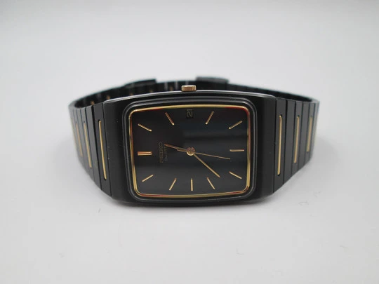 Seiko. Black and gold metal. Steel back. Quartz. Square case. Bracelet. 1980's. Japan