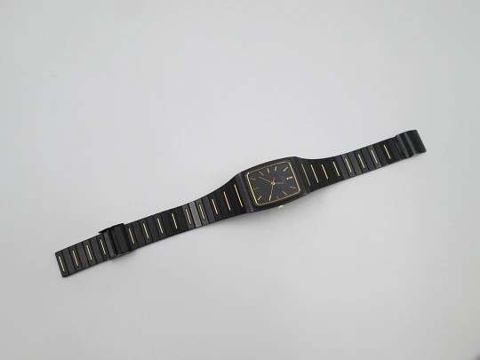 Seiko. Black and gold metal. Steel back. Quartz. Square case. Bracelet. 1980's. Japan