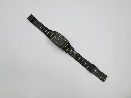 Seiko. Black and gold metal. Steel back. Quartz. Square case. Bracelet. 1980's. Japan