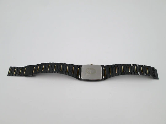 Seiko. Metal negro y oro. Fondo acero. Cuarzo. Caja cuadrada. Brazalete. 1980. Japón