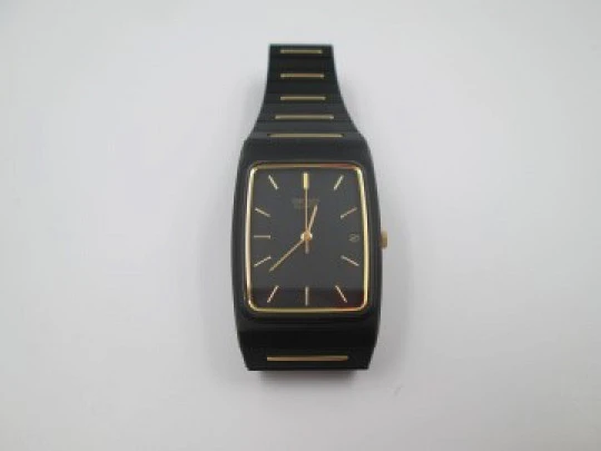 Seiko. Metal negro y oro. Fondo acero. Cuarzo. Caja cuadrada. Brazalete. 1980. Japón