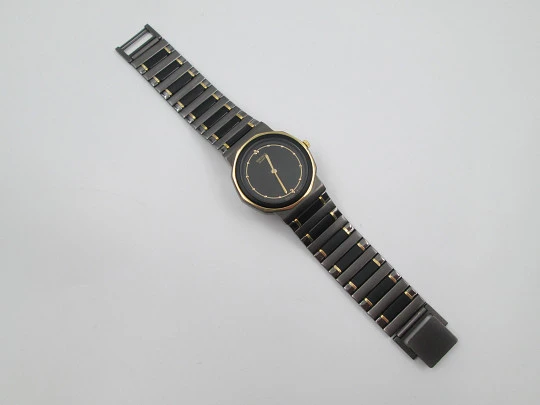Seiko. Metal negro y oro. Fondo acero. Cuarzo. Caja redonda. Brazalete. 1980. Japón