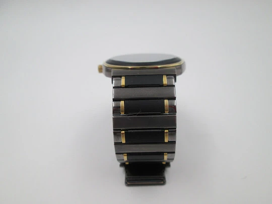 Seiko. Metal negro y oro. Fondo acero. Cuarzo. Caja redonda. Brazalete. 1980. Japón