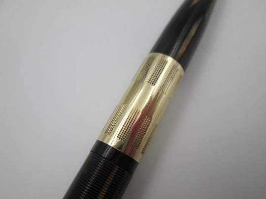 Sheaffer Tuckaway. Celuloide estriado marmolizado y chapados oro. Giratorio. 1940