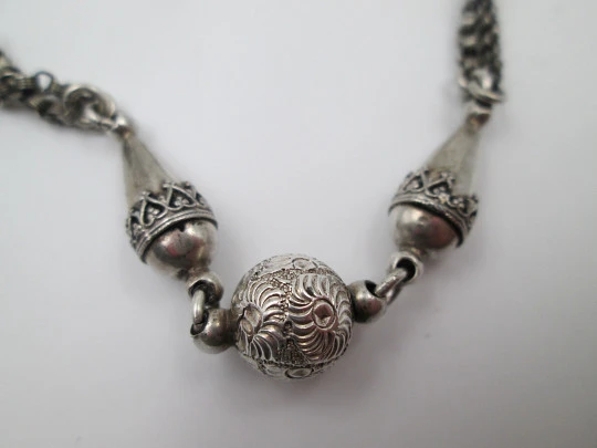 Silver pocket watch chain. Ball and acorns motifs. T-bar. Lobster clasp. Europe. 1910's