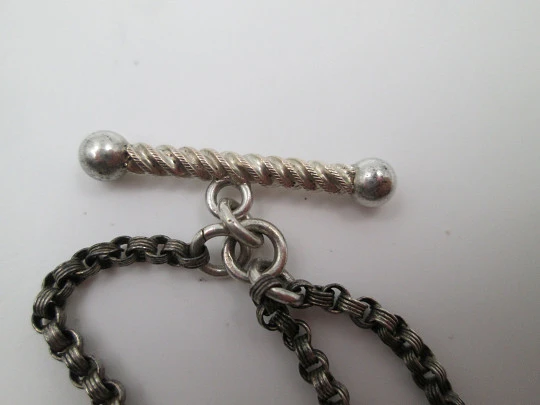 Silver pocket watch chain. Ball and acorns motifs. T-bar. Lobster clasp. Europe. 1910's