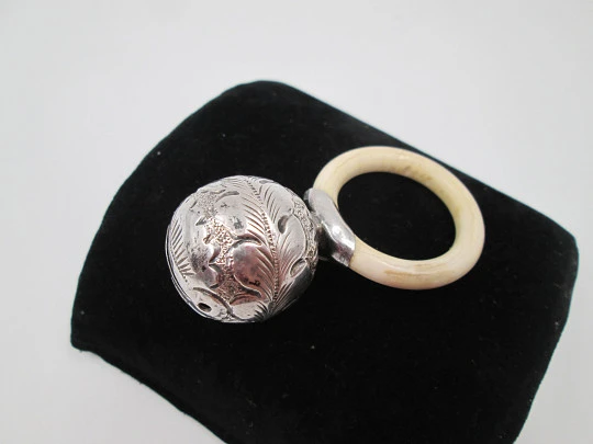 Sonajero infantil esfera decorada. Plata de ley. Motivos vegetales. Aro resina blanca. 1970