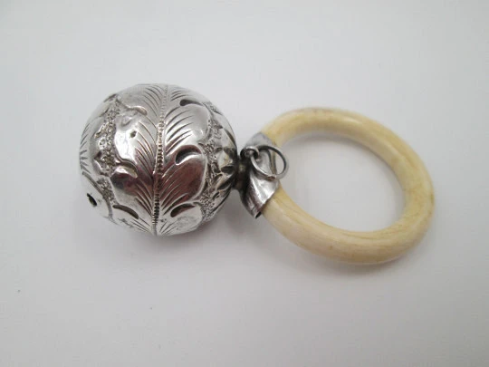 Sonajero infantil esfera decorada. Plata de ley. Motivos vegetales. Aro resina blanca. 1970
