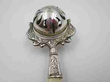 Sonajero. Plata de ley. Esfera calada y mango marfil. 1960. Estuche. Adornos florales