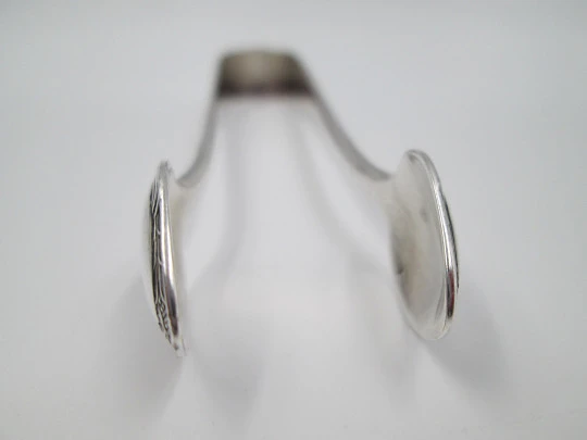 Sugar tongs. Silver plated metal. Ribbed design and flowers. Europe. 1950's