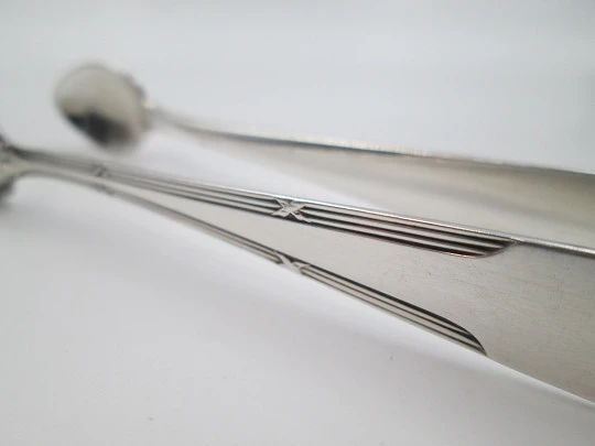 Sugar tongs. Silver plated metal. Ribbed design and flowers. Europe. 1950's