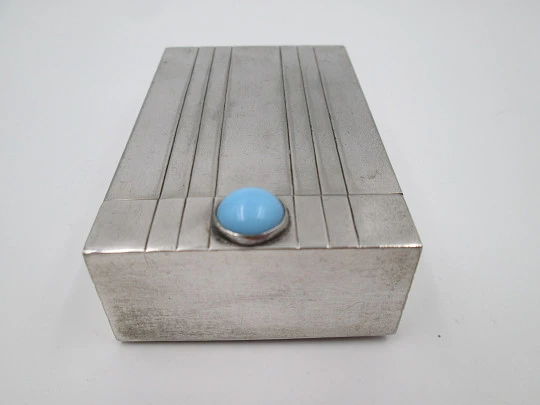 Tabaquera de alpaca. Motivos líneales. Tapa articulada con piedra cabujona azul. 1980