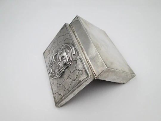 Tabaquera de despacho. Alpaca blanca. Tapa articulada. Motivo relieve ídolo inca. 1980