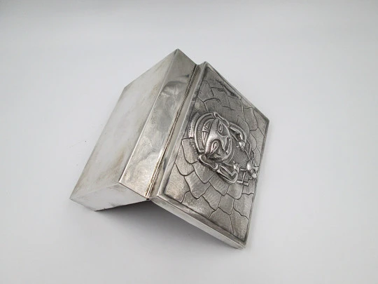 Tabaquera de despacho. Alpaca blanca. Tapa articulada. Motivo relieve ídolo inca. 1980