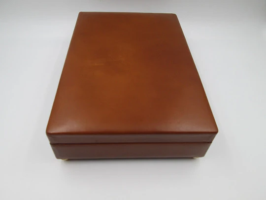 Tabaquera musical de despacho y escritorio. Madera y piel marrón. Cuerda manual. 1970